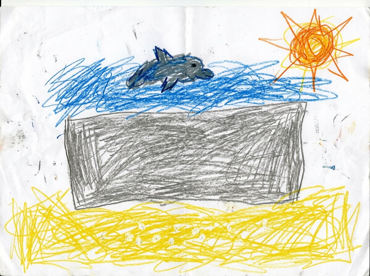 A crayon drawing of a grey wall between yellow sand and blue sea, with a dolphin and the sun above